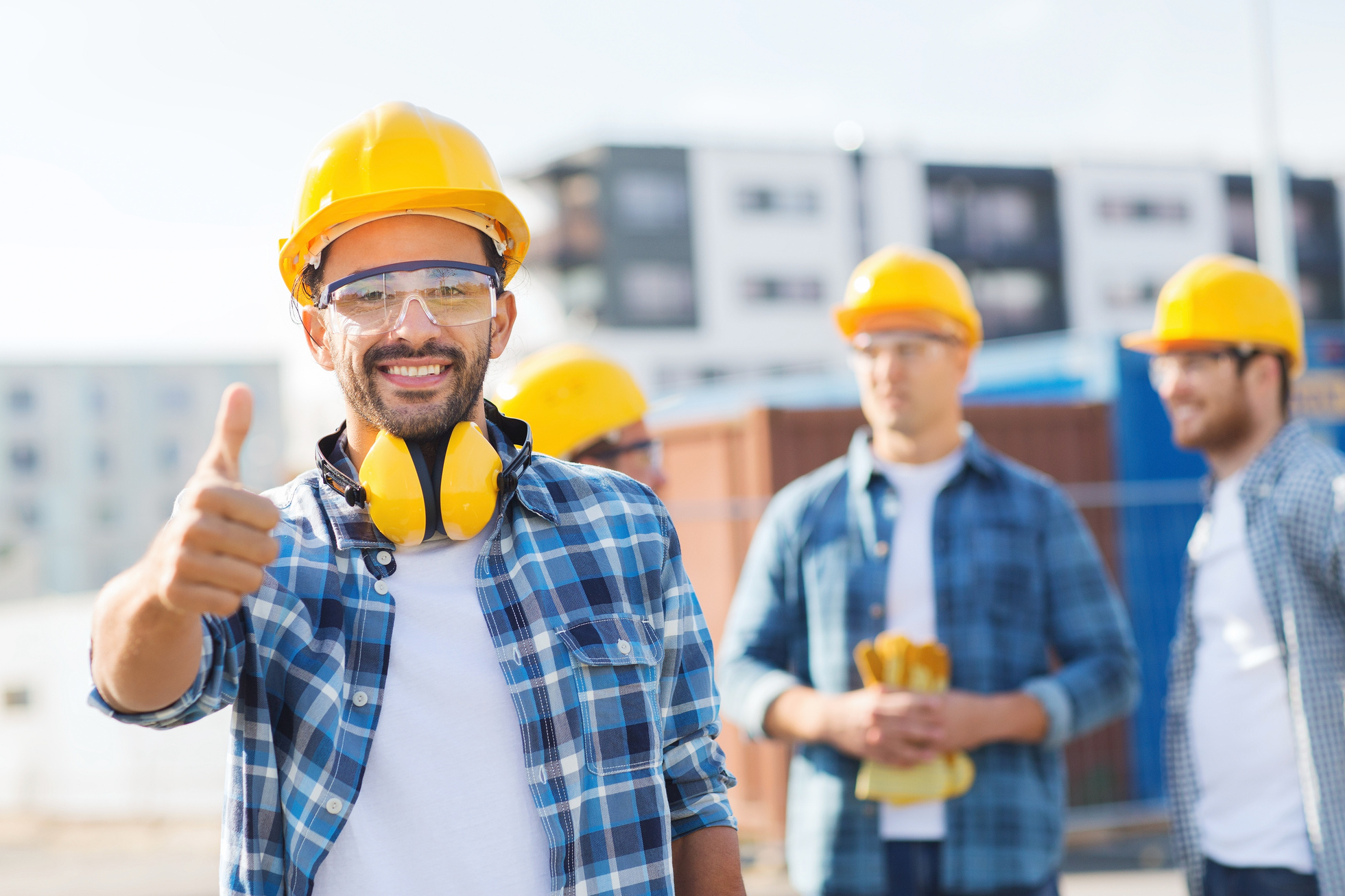Group of Smiling Builders in Hardhats Outdoors